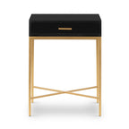 Black side table with a drawer and brass finish legs on a white background