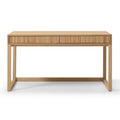 A light natural wood writing desk with two drawers featuring vertical slat fronts and a matching  top, supported by four angled legs, shown against a plain white background.