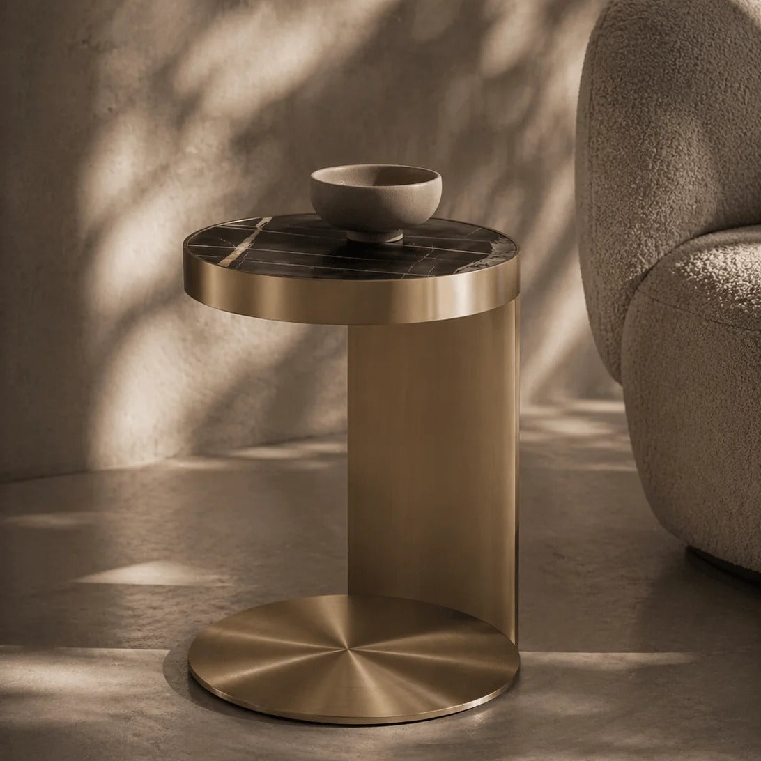 Gold side table with a bowl on a neutral background